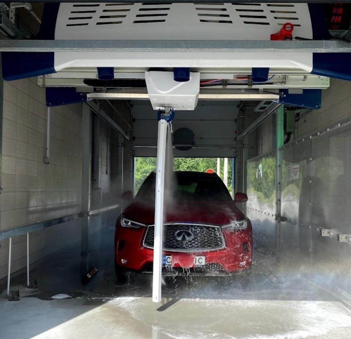 Touchless robotic car-wash system washing a car